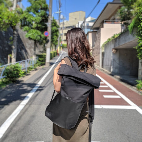 Model wearing Braasi Ayo backpack made out of black cotton canvas and black Italian leather.