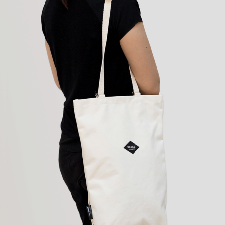 A model wearing the white Braasi Canvas Bag over her shoulder